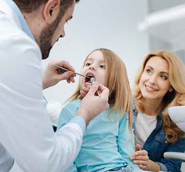 Dentist examining child's smile