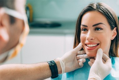 Orthodontist looking at patient's smile after braces