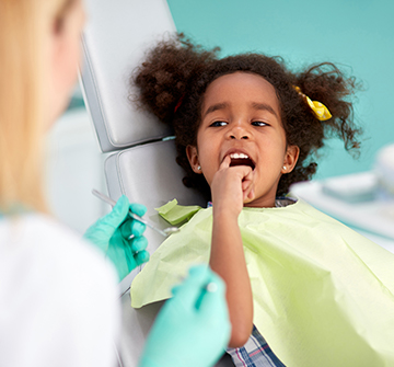 Little girl pointing to tooth after root canal