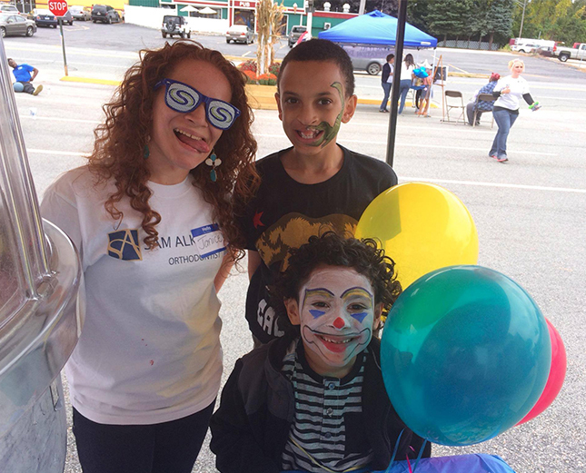 Team member with children at community event