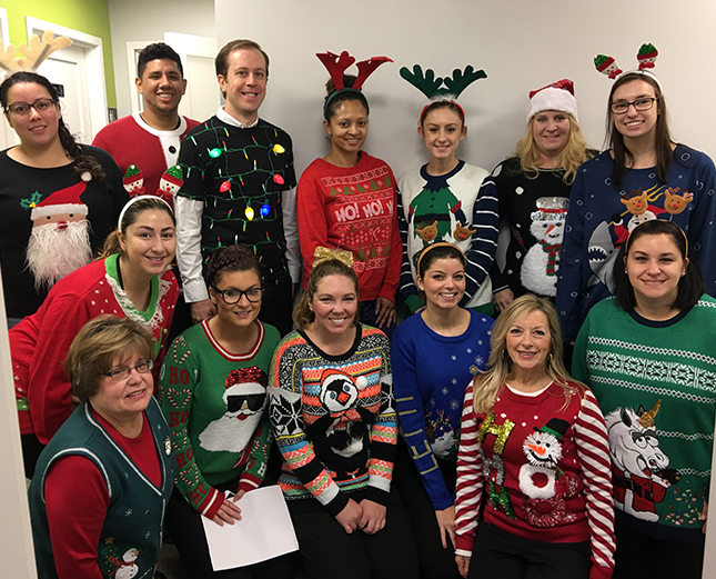 Team members in Christmas sweaters