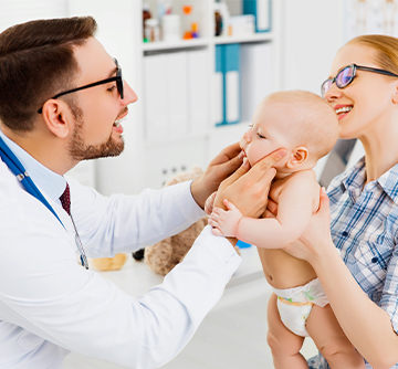 Dentist examining baby during oral health risk assessment