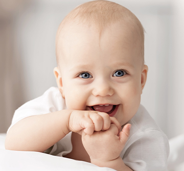 Teething baby chewing on his fingers