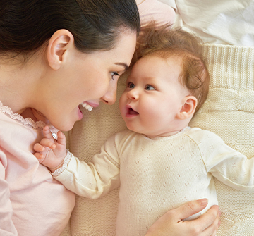 Mother and baby smiling after frenectomy treatment