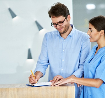 Patient and dental assistant reviewing the cost of Invisalign