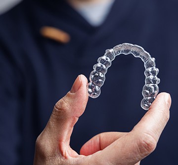 Closeup of patient holding Invisalign aligner