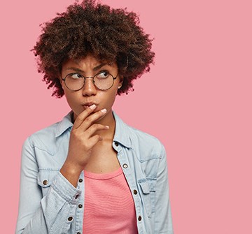 Woman on pink background with questions about Invisalign in Randolph 