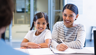 Mother and daughter checking in at dental office reception desk