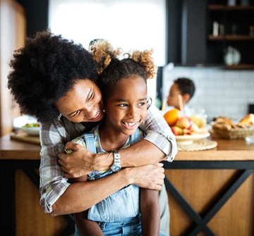 Mom hugging daughter in kitchen