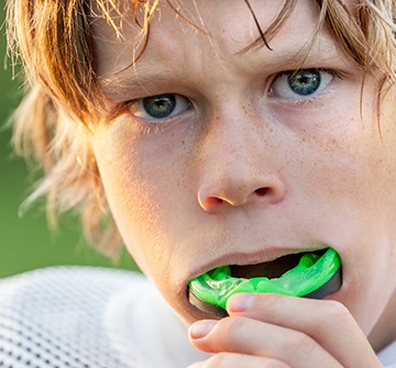 Child smiling at parent while eating healthy lunch at home