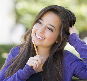 Teen smiling after dental crown restoration