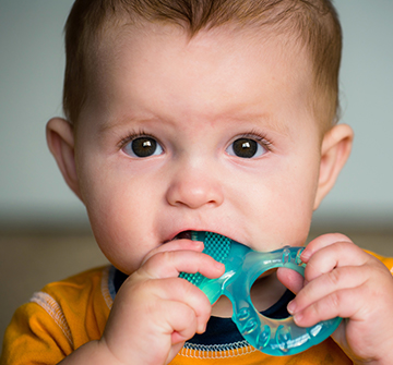 Child chewing on teething ring