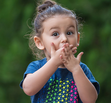 Little girl in need of emergency dentistry covering her mouth