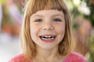 Young girl with braces smiles after visiting Randolph orthodontist 