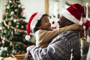 Family in Santa hats heeding Randolph children's emergency dentist holiday tips