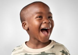 Child smiles after learning how to prevent cavities in kids