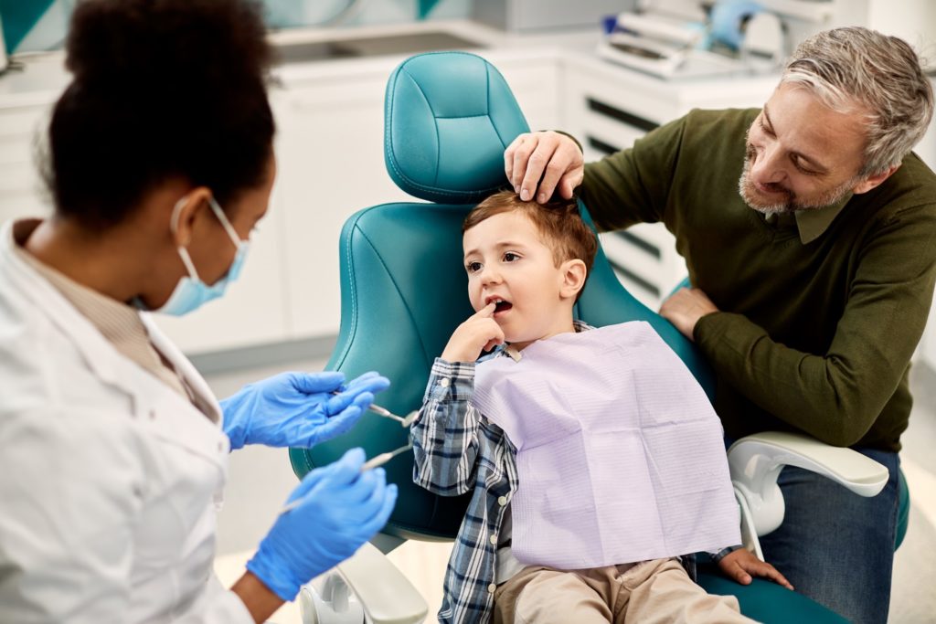 Dentist and father with child at dental checkup