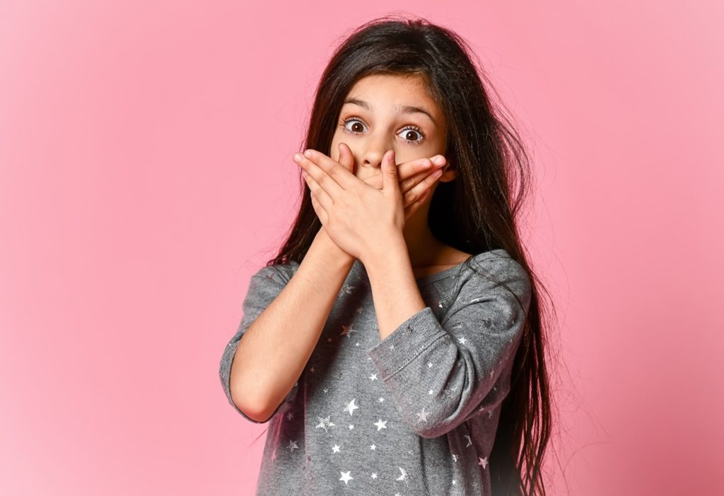 Young girl covering her mouth in shock