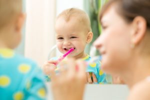 mother and baby practicing child's oral hygiene