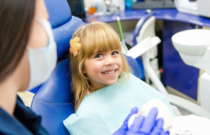 a child smiling while visiting their dentist 